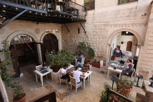 a group of people sitting at tables in a restaurant at Tuğhan Hotel in Mardin