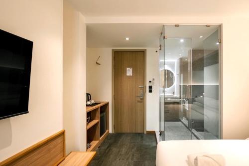 a bathroom with a sliding glass door leading to a bedroom at ZEN MASTER HOTEL in Bangkok