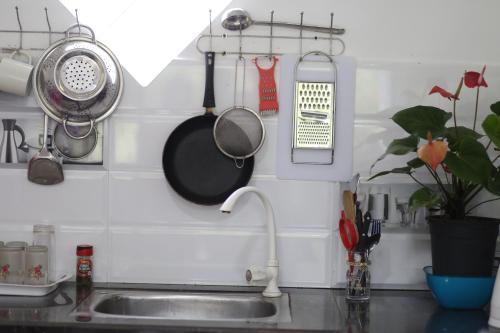 a kitchen sink with utensils hanging on a wall at Bakery Family Guest House in Mirissa