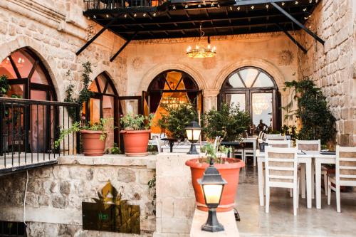 a restaurant with tables and chairs in a building at Tuğhan Hotel in Mardin