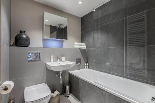 a bathroom with a sink and a tub and a toilet at Apartments in Lake District in Backbarrow