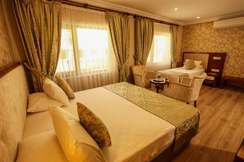 a hotel room with two beds and a desk at Tuğhan Hotel in Mardin