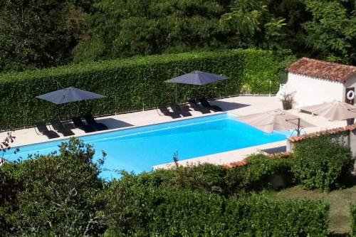 une piscine avec chaises et parasols à côté d'un bâtiment dans l'établissement 3 bedroom apartment in the grounds of a Chateau, à Saint-Paul-Lizonne