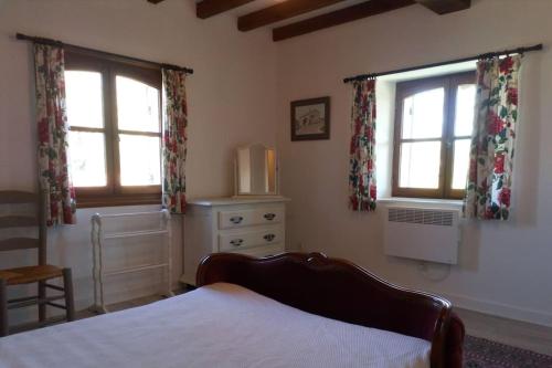 une chambre avec un lit et deux fenêtres dans l'établissement 3 bedroom apartment in the grounds of a Chateau, à Saint-Paul-Lizonne