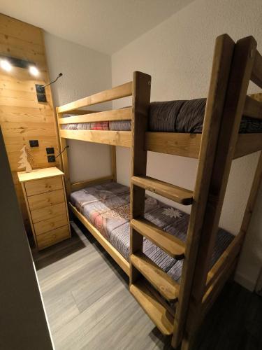 deux lits superposés dans une chambre avec un bureau dans l'établissement Roche Blanche Appartements VTI, à Val Thorens