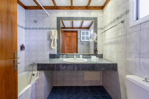 bagno con lavandino, vasca e specchio di Palladium hotel a Marmári