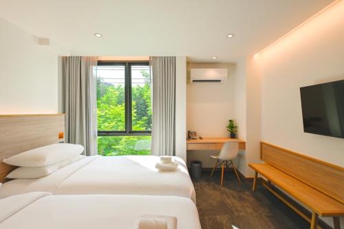 バンコクにあるZEN MASTER HOTELのベッド、デスク、テレビが備わるホテルルームです。