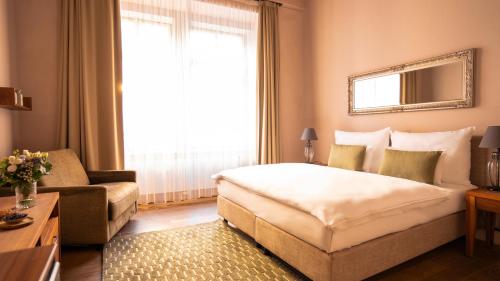 a hotel room with a large bed and a couch at Hotel Golden Key Prague Castle in Prague