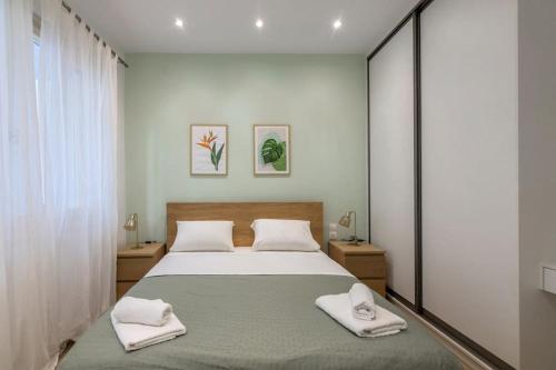 a bedroom with a bed with two towels on it at The 626 Park Apartment in Heraklio