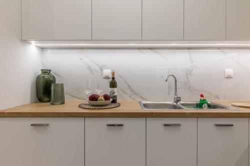 a kitchen counter with a sink and a bottle of wine at The 626 Park Apartment in Heraklio