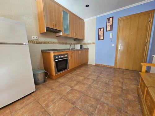 a kitchen with wooden cabinets and a refrigerator at 21A02 Coqueto apartamento con garaje in Felechosa