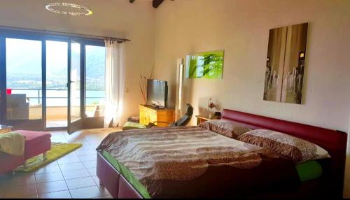 um quarto com uma cama grande e uma televisão em Viaggi del Lea vista Lago Maggiore em Piazzogna