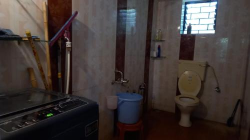 a small bathroom with a toilet and a window at Terrace House Goa in Arambol