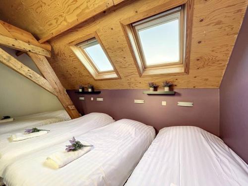 two beds in a room with two windows at Blauwhof - Steenkerke in Veurne