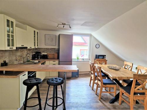 eine Küche und ein Esszimmer mit einem Tisch und einem Kühlschrank in der Unterkunft charmantes Landhaus "Wildrose", kurz vor Halle, 4 Schlafzimmer in Petersberg