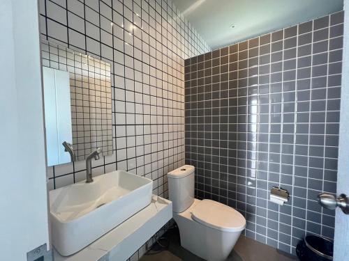 ein Badezimmer mit einem weißen WC und einem Waschbecken in der Unterkunft Krin Resort in Khao Kho