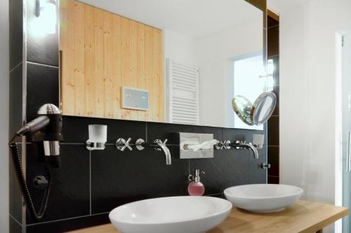 een badkamer met 2 wastafels en een spiegel bij Resort Deichgraf Resort Deichgraf 31-03 in Wremen