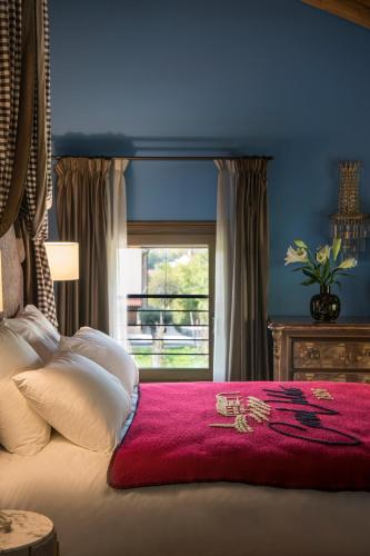 a bedroom with a bed with a red blanket and a window at Casa Valdo Country House in Valdobbiadene