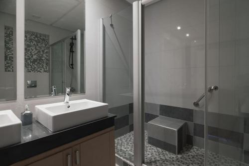 a bathroom with two sinks and a glass shower at Beautifully Designed 3BR Apartment+ Panoramic View in Rabat