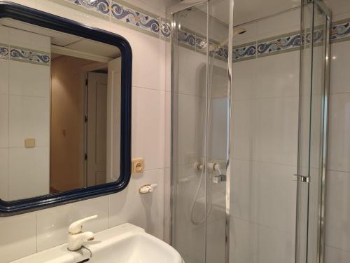 y baño con ducha, lavabo y espejo. en Bonito ático en la judería de Córdoba, en Córdoba