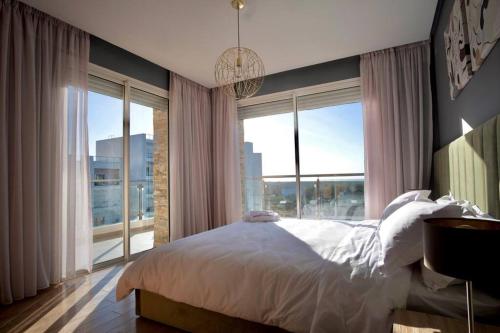 a bedroom with a bed and a large window at Beautifully Designed 3BR Apartment+ Panoramic View in Rabat