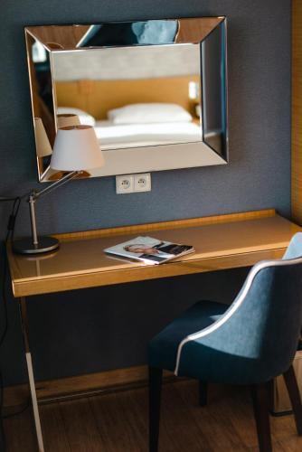 a desk with a lamp and a mirror over a bed at Hotel Marina Club Old Town View in Gdańsk