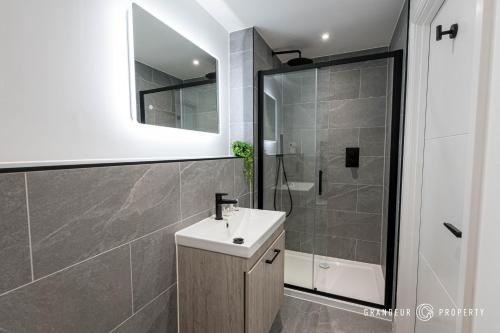 a bathroom with a sink and a glass shower at NEW Elegant apartment, 2 bed, balcony, Poole - Aurora's Abode in Parkstone