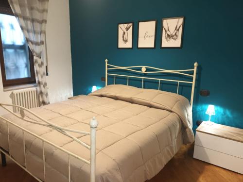 una camera da letto con un letto bianco e pareti blu di La casa di Elenù a Posillipo a Napoli