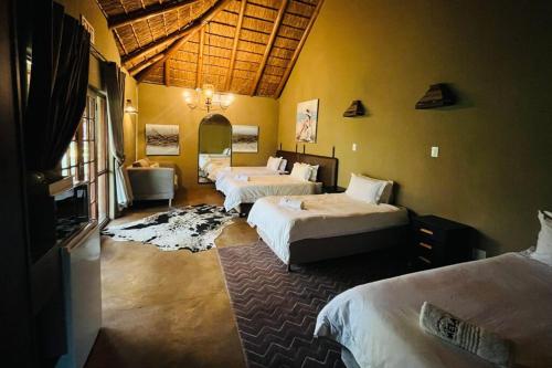 a hotel room with two beds and a bathroom at Mela Luxury Game Lodge in Pretoria
