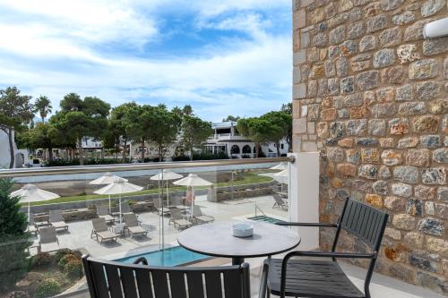 a patio with a table and chairs and a pool at Palladium hotel in Marmari