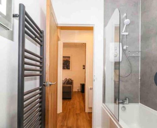 a bathroom with a shower and a glass door at The Butcher's Flat Seahouses in Seahouses