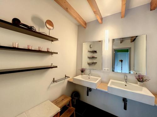 a bathroom with two sinks and a mirror at Blauwhof - Steenkerke in Veurne