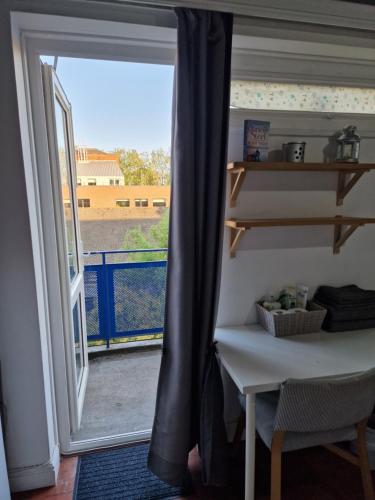 a room with a door open to a balcony with a table at Spacious room private balcony - Central London - zone 1 - Elephant and Castle in London
