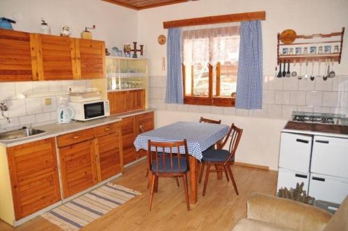 a kitchen with a table and chairs in a kitchen at Drevenica Baltazár in Liptovská Lúžna