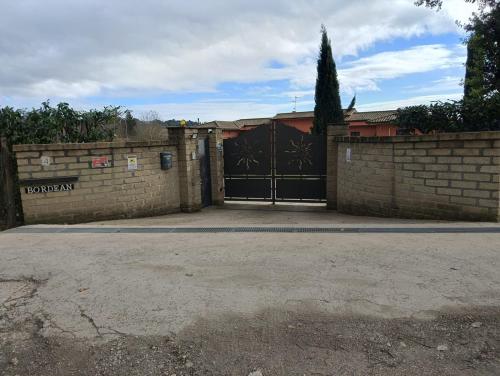 a garage with a black gate and a brick wall at Tenuta Quadrone in Cura