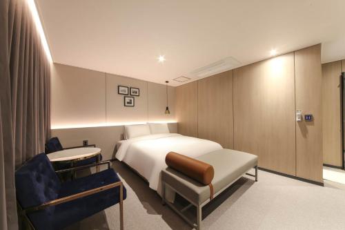 a hotel room with a bed and a chair at HOUND HOTEL sasang branch in Busan