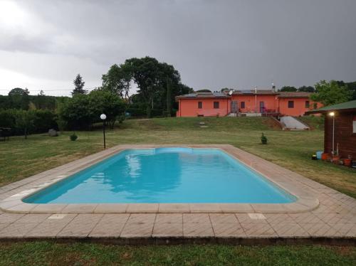 a large swimming pool in a yard with a house at Tenuta Quadrone in Cura