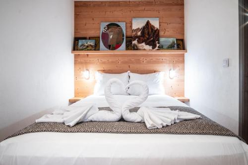 ein Bett mit zwei Handtüchern in Form von Schwänen in der Unterkunft Le Savoy - Terrasse avec vue sur le Mont-Blanc in Chamonix-Mont-Blanc