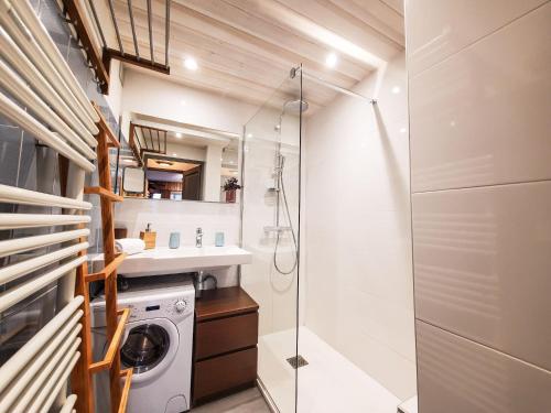 une salle de bain avec douche et machine à laver dans l'établissement Le Savoy - Terrasse avec vue sur le Mont-Blanc, à Chamonix-Mont-Blanc