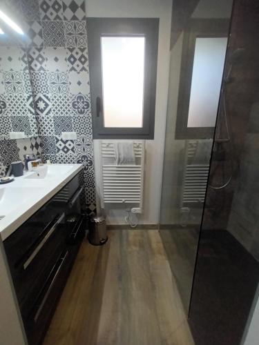 La salle de bains est pourvue d'un lavabo, d'une douche et d'une fenêtre. dans l'établissement Moulleau - charmante maison 4 chambres et jardin privé, à La Teste-de-Buch