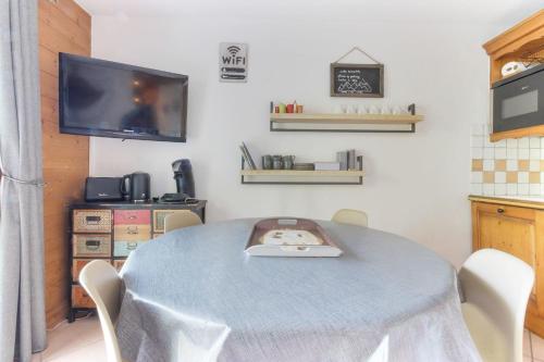 d'une salle à manger avec une table, des chaises et une télévision. dans l'établissement Albertine - Centre de Chamonix - Garage - Mountain Views!, à Chamonix-Mont-Blanc