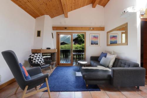 un salon avec un canapé et deux chaises dans l'établissement Chalet Kandahar - Piscine intérieure - Parc & Lac des Chavants - Escalade - Sentiers de Randonnée, aux Houches