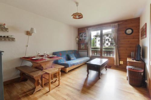 un salon avec un canapé bleu et une table dans l'établissement Les Capucins - Calm - Mont-Blanc - Lake Gaillland, à Chamonix-Mont-Blanc
