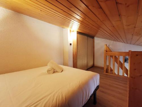 ein Schlafzimmer mit einem weißen Bett und einer Holzdecke in der Unterkunft Clos du Savoy - Chamonix Center - Skii on foot in Chamonix-Mont-Blanc