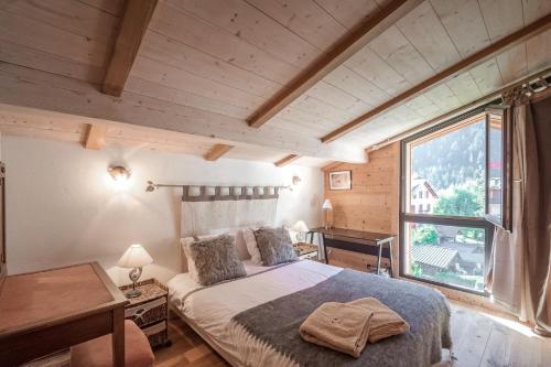 sypialnia z łóżkiem i dużym oknem w obiekcie L'écrin des Bossons w Chamonix-Mont-Blanc