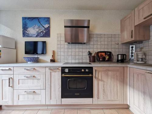 une cuisine avec une cuisinière et un micro-ondes dans l'établissement Sun Valley 3 - Vue Mont-Blanc, à Chamonix-Mont-Blanc