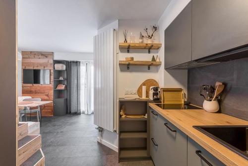 une cuisine avec des armoires blanches et un comptoir dans l'établissement Les Cîmes du Mont-Blanc, à Chamonix-Mont-Blanc