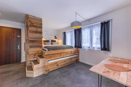 - une chambre avec un lit et un mur en bois dans l'établissement Les Cîmes du Mont-Blanc, à Chamonix-Mont-Blanc