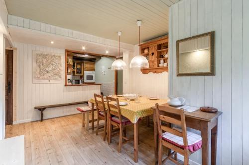 cocina y comedor con mesa y sillas en Clos de l'Ours - 2 chambres - Jardin privé, en Chamonix-Mont-Blanc