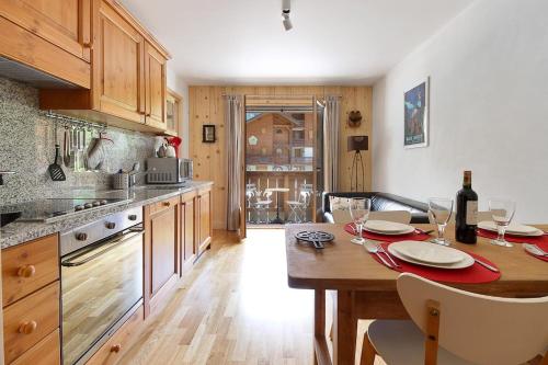 - une cuisine avec une table en bois et des verres à vin dans l'établissement Les Alpages - Newly Renovated - 2bed - Equipment Storage - Mont-Blanc Views, aux Houches